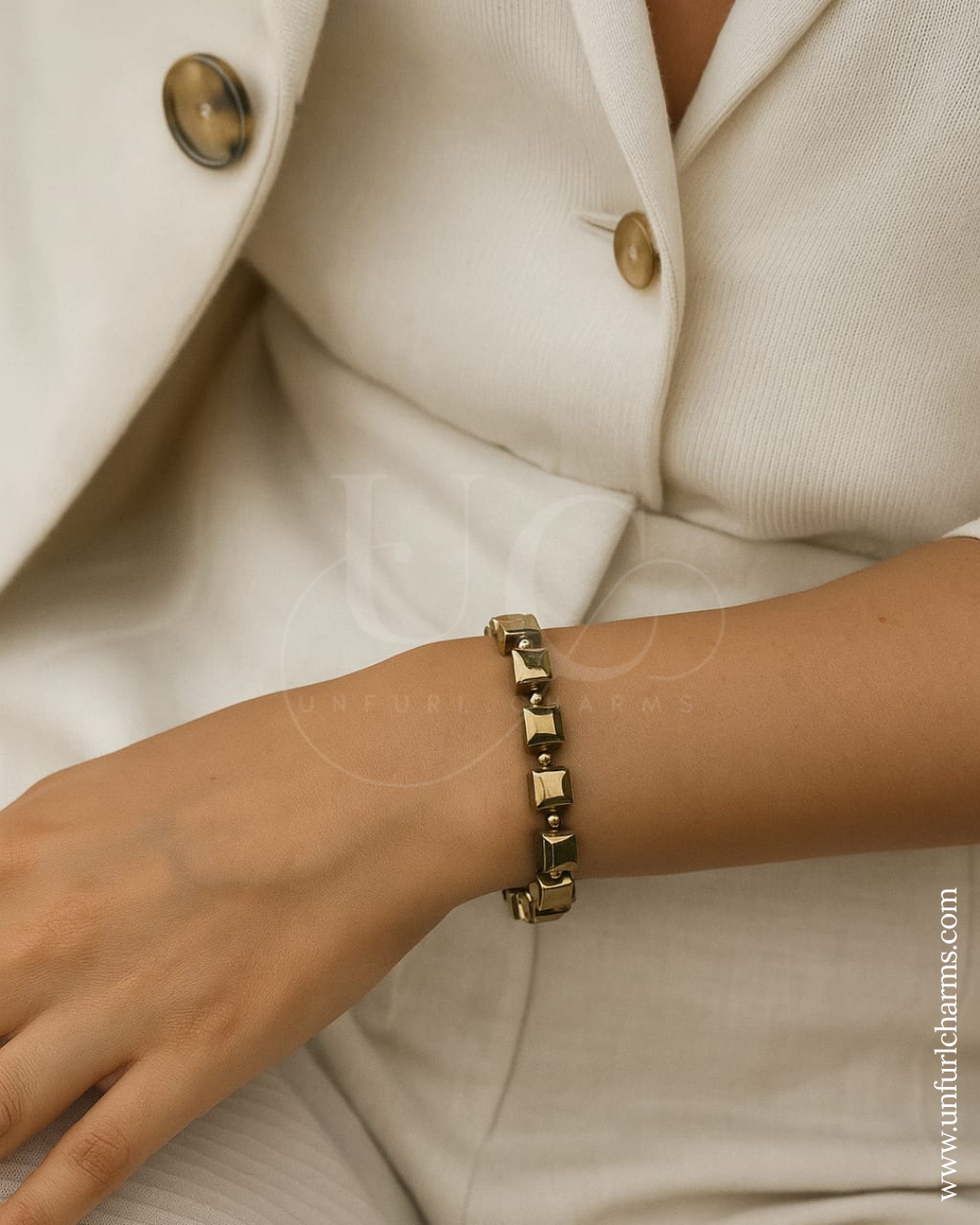 Gold bracelet on a wrist with a neutral background. Unisex energy bracelet with jute pouch & blessing scroll