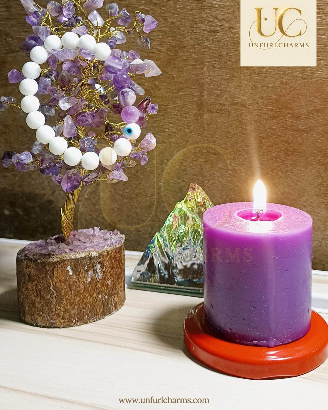Purple candle with a tree of crystals and a stone on a wooden surface, branded 'Unfurlcharms'. Spirituality at core. delivery fast. Made in India