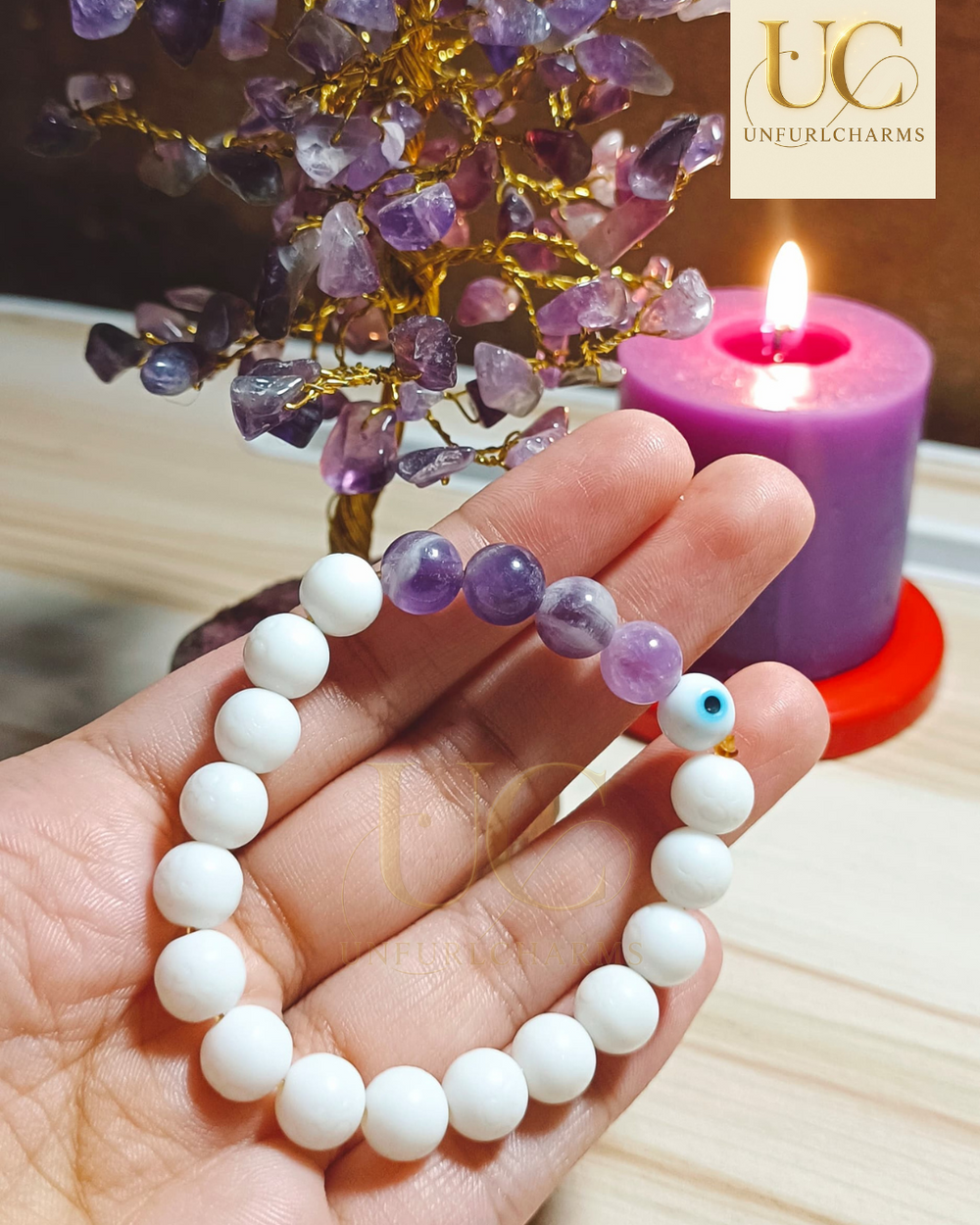 Hand holding a white beaded bracelet with purple beads, UnfurlCharms. Perfect for gifting purposes.