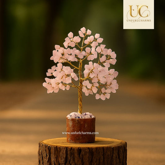 Decorative pink crystal tree on a wooden base with 'Unfurl Charms' branding.
