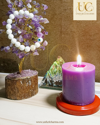 Purple candle with a tree of crystals and a stone on a wooden surface, branded 'Unfurlcharms'. Spirituality at core. delivery fast. Made in India